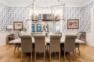 Dining room with ornamental molding, a notable chandelier, and wood-type flooring