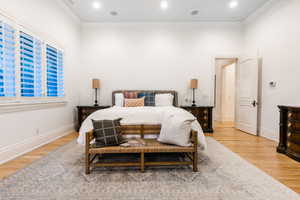 Bedroom with hardwood / wood-style flooring and ornamental molding