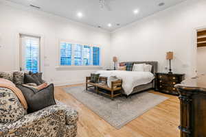 Bedroom with ornamental molding, hardwood / wood-style floors, and ceiling fan