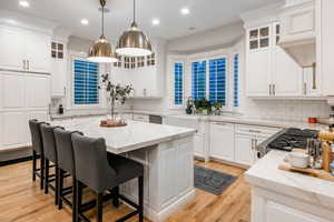 Kitchen featuring backsplash, white cabinetry, and a kitchen island