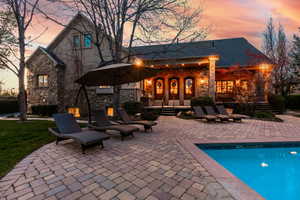 Back house at dusk featuring french doors and a patio area