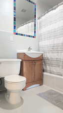 Full bathroom featuring tile patterned floors, vanity, shower / bathtub combination with curtain, tile walls, and toilet