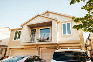 Townhome / multi-family property featuring a garage and a balcony