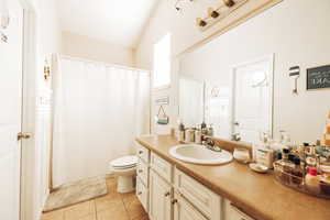 Bathroom featuring tile patterned floors, toilet, walk in shower, and vanity