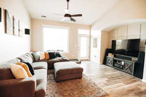 Living room with vaulted ceiling, hardwood / wood-style flooring, and ceiling fan