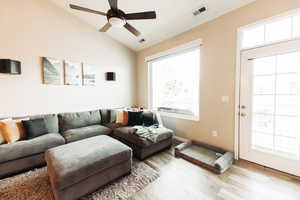 Living room with vaulted ceiling, light wood-type flooring, and ceiling fan