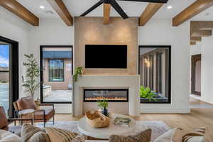 Living room featuring light hardwood / wood-style floors and beamed ceiling