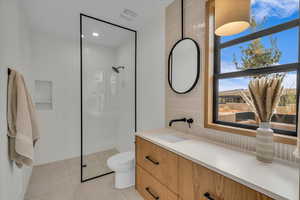 Bathroom with vanity, tasteful backsplash, tile patterned floors, toilet, and walk in shower