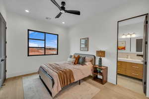 Bedroom featuring connected bathroom, light hardwood / wood-style flooring, and ceiling fan