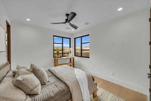 Bedroom with hardwood / wood-style floors and ceiling fan