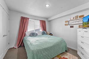 Carpeted bedroom with a textured ceiling