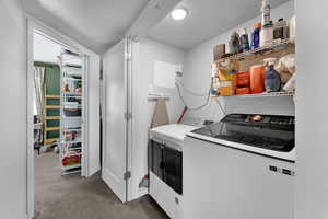 Clothes washing area with dark carpet, a textured ceiling, and independent washer and dryer