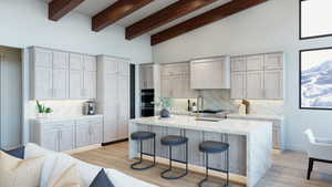 Kitchen featuring a center island with sink, light hardwood / wood-style flooring, tasteful backsplash, and high vaulted ceiling