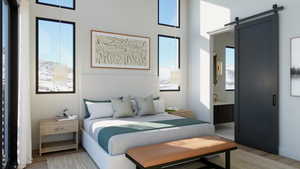 Bedroom featuring a barn door and hardwood / wood-style flooring