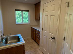 Laundry rooom with sink, cabinets, closet, and pantry