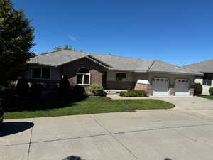 Ranch-style house with a garage and a front yard