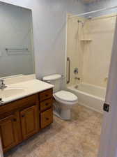 Full bathroom featuring vanity, bathing tub / shower combination, toilet, and tile patterned floors nd sponge painting