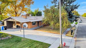 View of front facade with a carport and a front yard