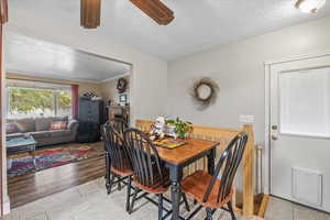 Dining space featuring ceiling fan, light hardwood / wood-style floors, and a textured ceiling