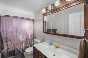 Bathroom with walk in shower, tile patterned floors, vanity, and toilet