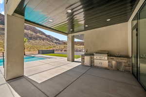 View of patio / terrace with area for grilling, a mountain view, sink, and a grill.Old photo. The water slide has been installed. Landscape has changed