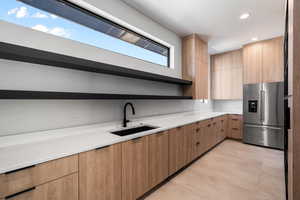 Kitchen with sink, high end refrigerator, and light brown cabinets