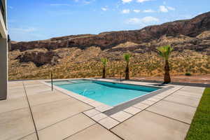 View of swimming pool featuring a mountain view and a patio area. Old photo. The water slide has been installed. Landscape has changed