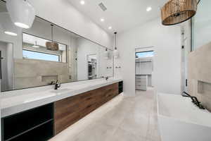 Bathroom featuring vanity and independent shower and bath