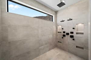 Bathroom with a mountain view, tiled shower, and a healthy amount of sunlight