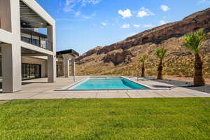 View of swimming pool featuring a yard and a patio area. Old photo. The water slide has been installed. Landscape has changed