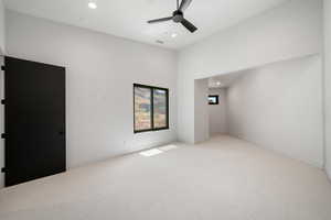 Carpeted empty room with ceiling fan