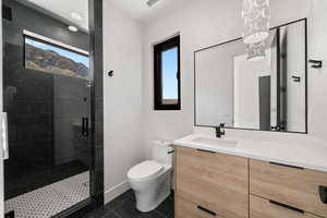 Bathroom with an enclosed shower, vanity, tile patterned flooring, and toilet