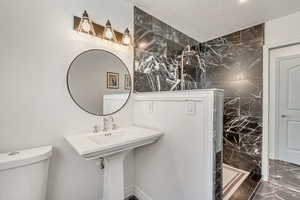 Bathroom featuring tile walls, a textured ceiling, and toilet