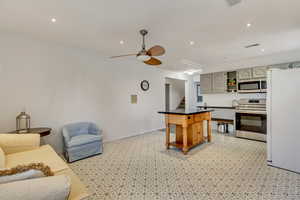 Kitchen featuring stainless steel appliances, a kitchen island, gray cabinetry, and ceiling fan