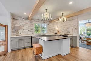 Kitchen featuring light hardwood / wood-style floors, hanging light fixtures, an inviting chandelier, and dishwasher