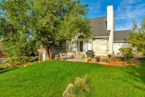 Back of property with a lawn and a patio area