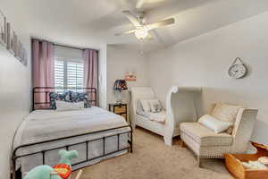 Bedroom with ceiling fan and light colored carpet