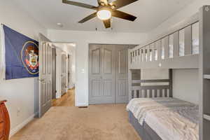 Carpeted bedroom with a closet and ceiling fan