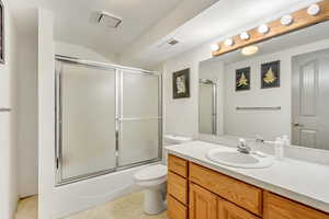 Full bathroom featuring vanity, toilet, and enclosed tub / shower combo