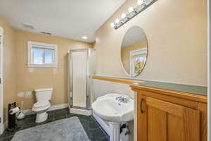 Bathroom with visible vents, toilet, a shower stall, tile patterned flooring, and baseboards