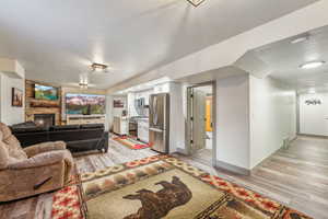 Living area featuring light wood-style floors, a fireplace, and baseboards