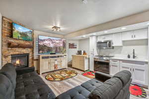 Living room featuring a textured ceiling, light wood-type flooring, and a fireplace
