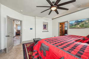 Carpeted bedroom featuring a ceiling fan, visible vents, and a textured ceiling