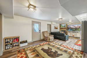Living area featuring a fireplace, baseboards, and wood finished floors