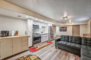 Living area featuring light wood finished floors, visible vents, and recessed lighting
