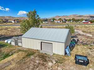 View of outdoor structure featuring an outbuilding, driveway, a mountain view, and a garage