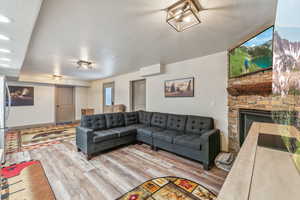 Living room with recessed lighting, a fireplace, and wood finished floors