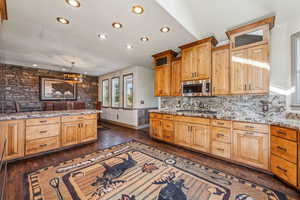 Kitchen with dark wood finished floors, stainless steel appliances, recessed lighting, decorative backsplash, and light stone countertops