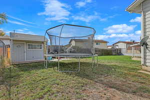 View of yard with a shed and a trampoline