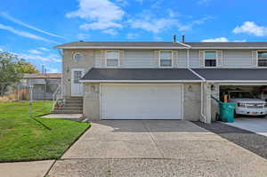 View of front of property featuring a garage and a front lawn